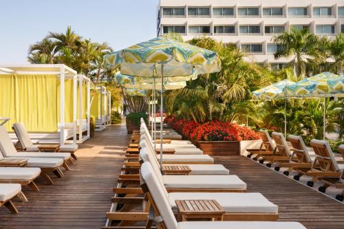 a row of chairs and umbrellas on a boardwalk at Lagoona by Isrotel Collection in Eilat