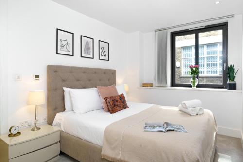 a white bedroom with a large bed with a window at Trafalgar SQ 1 Bedr, 3 Beds sleeps 6 in London
