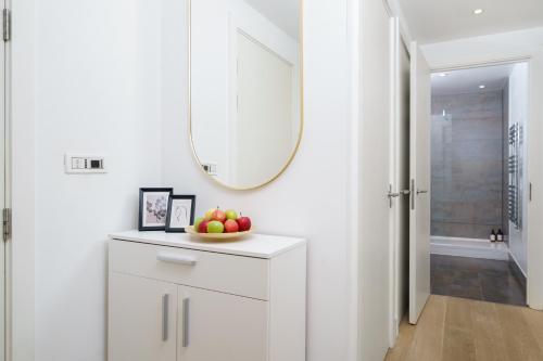 a white hallway with a bowl of fruit on a counter at Trafalgar SQ 1 Bedr, 3 Beds sleeps 6 in London