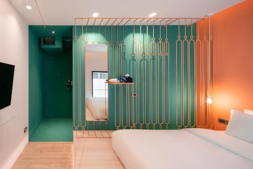 a bedroom with a bed and green and orange walls at Speck Bangkok in Bangkok