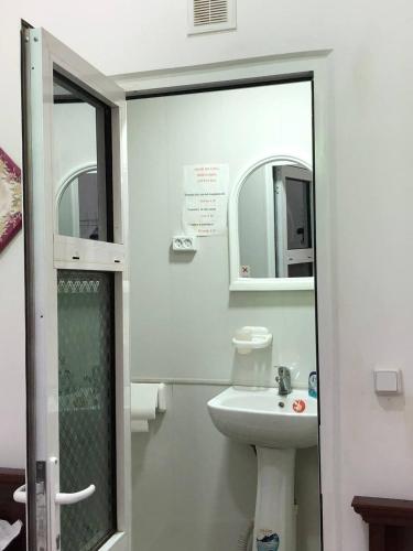 a bathroom with a sink and a toilet and a mirror at Khan Rooms in Bukhara