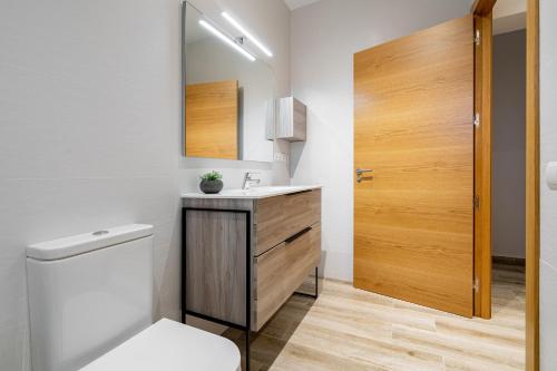 a bathroom with a toilet and a sink and a mirror at Casa Turón in Deltebre