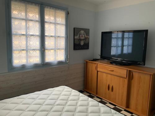 - une chambre avec une télévision à écran plat sur une commode en bois dans l'établissement Villa Magaly T3 à 50 m de la plage Valras centre, à Valras-Plage
