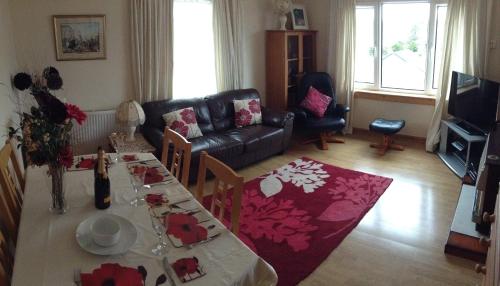 a living room with a table and a couch at Westview Accommodation in Stornoway