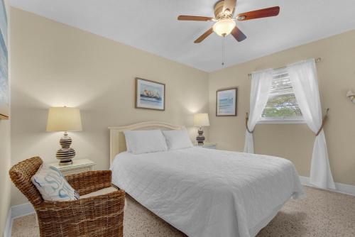 a bedroom with a bed and a ceiling fan at Bungalow By the Sea in Navarre