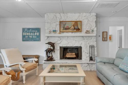a living room with a fireplace and a blue couch at Bungalow By the Sea-Mermaid in Navarre