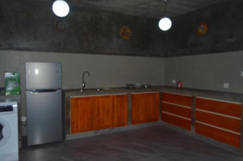 a kitchen with a stainless steel refrigerator and wooden cabinets at Mojito Beach Villas in Kubutambahan