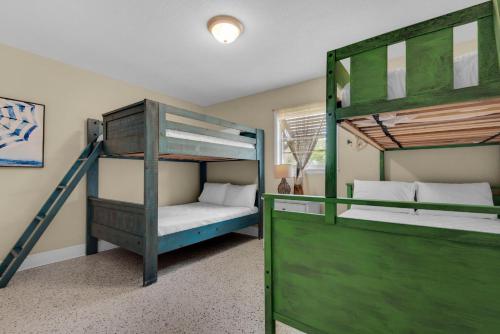 a bedroom with two bunk beds and a ladder at Bungalow By the Sea in Navarre