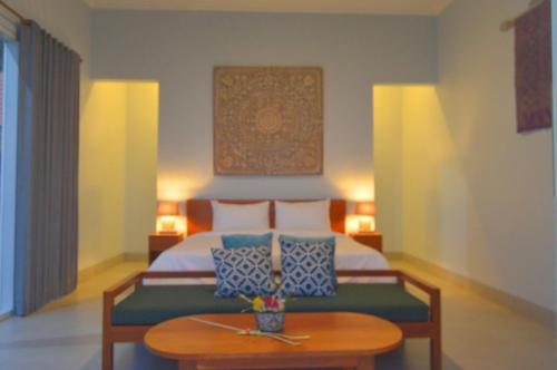 a bedroom with a bed and a wooden table at Mojito Beach Villas in Kubutambahan