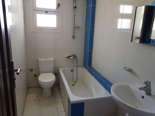 a bathroom with a toilet and a tub and a sink at Chalet at lazourde bay in El Alamein
