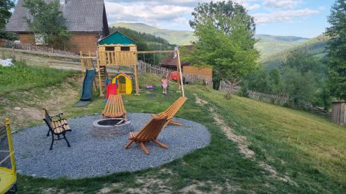 a playground with two swings and a play set at Casa Alexia in Mătişeşti