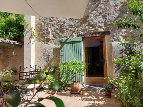 a stone house with a green door and some plants at 17th Century town house in Forcalquier centre in Forcalquier