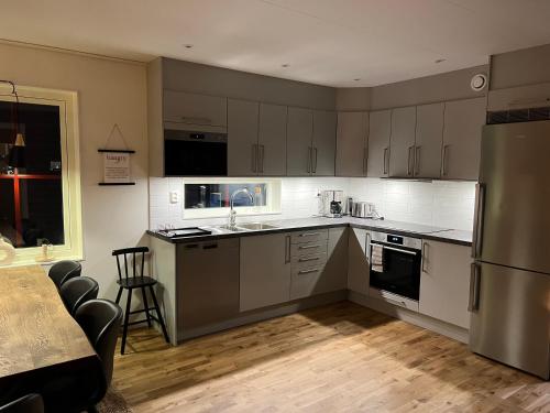 a kitchen with white cabinets and stainless steel appliances at Storhogna Torg in Vemdalen