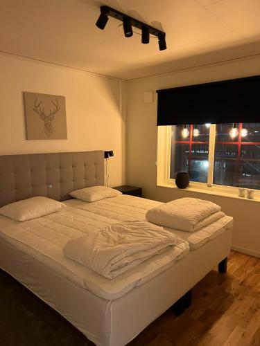 a bedroom with a large white bed with a window at Storhogna Torg in Vemdalen