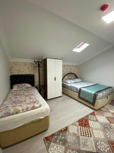 a bedroom with two twin beds and a rug at Uzungöl Özkan Pansiyon in Uzungöl