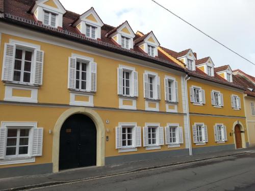 a yellow building with white windows and a door at Gästehaus Ferk - Frühstückspension, Bed & Breakfast in Bad Radkersburg