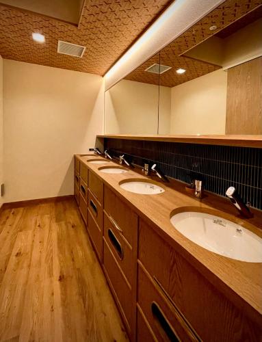 a bathroom with two sinks and a large mirror at SPABLIC INN - Capsule Hatago Akasaka in Tokyo
