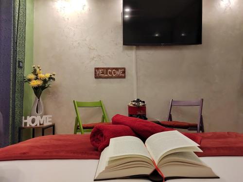 an open book on a bed with a table and chairs at Ping in Lukavica