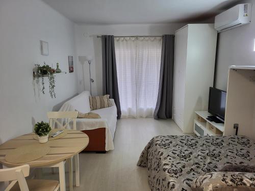 Habitación pequeña con cama, mesa y sofá. en Apartamento a 100 m de la playa! en Torroella de Montgrí