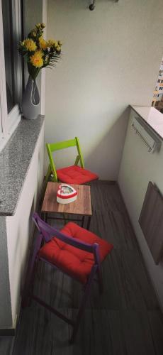 a small room with two chairs and a table with a vase of flowers at Ping in Lukavica