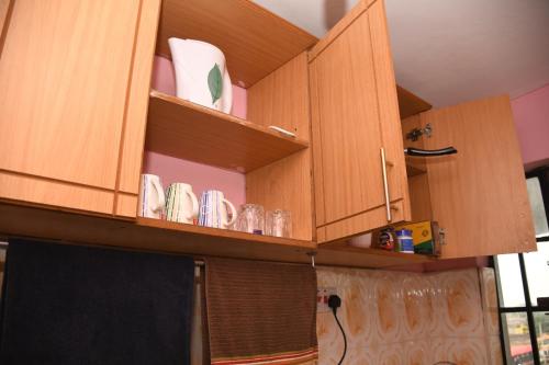 a kitchen cabinet with cups and plates on it at Jiji Homes 1 Bedroom house with Wi-Fi king size bed. Free parking in Naivasha