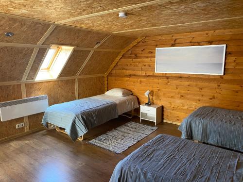 um quarto com 2 camas num quarto de madeira em Urmas Rehvid Holiday Home em Põlva