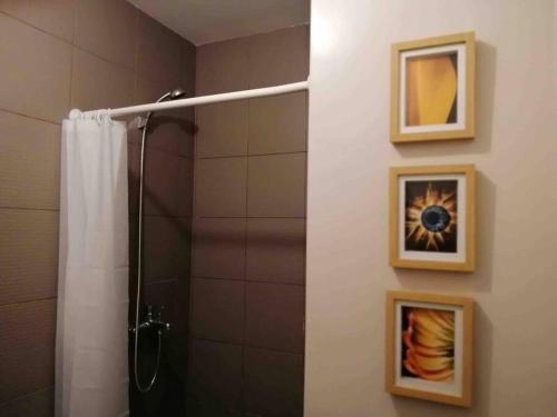 eine Dusche im Bad mit zwei Bildern an der Wand in der Unterkunft Budget price condo near IT Park & Ayala, Cebu City in Cebu City