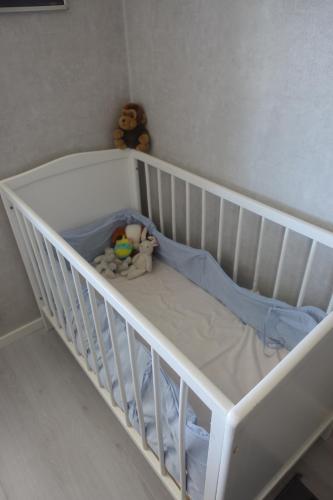 a white crib with a stuffed animal sitting in it at Views of Isaberg and fitting two families! in Hestra