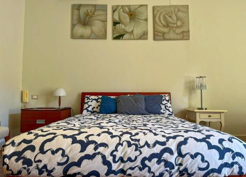 1 dormitorio con 1 cama con 4 cuadros en la pared en Chez Marie Napoli, en Nápoles