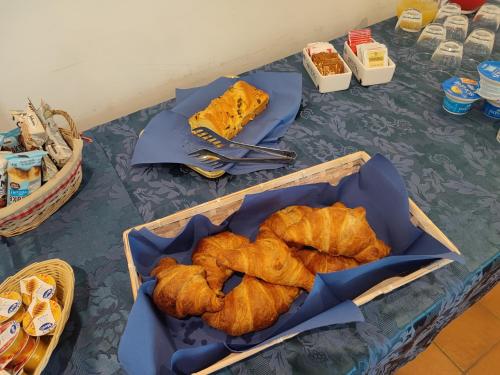 einen Tisch mit einem Tablett mit Croissants und Brot darauf in der Unterkunft Hermitage Ravello in Ravello