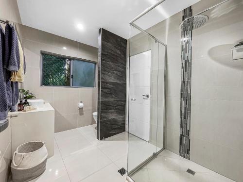 uma casa de banho com uma cabina de duche ao nível do chão e um WC. em Casa Mia Retreat Luxury Family Home on Buderim em Buderim