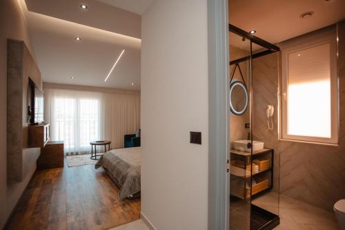 ein Schlafzimmer mit einem Bett und ein Badezimmer mit einem Spiegel in der Unterkunft Centropolis Apartments in Shkodra