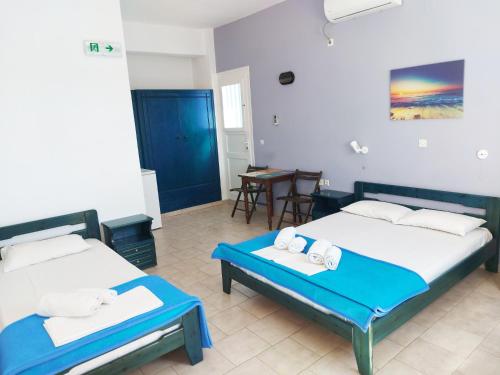 a hotel room with two beds and a table at Aigaio studios & rooms in Azolimnos
