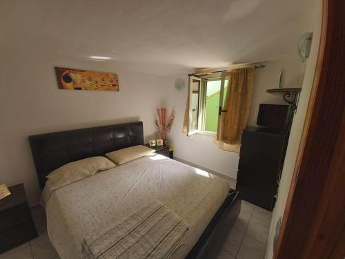 Schlafzimmer mit einem Bett und einem Fenster in der Unterkunft Casa Antonella in Dolianova