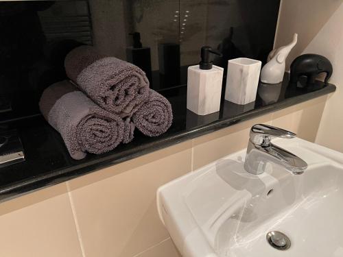 W łazience znajduje się umywalka, lustro i ręczniki. w obiekcie Dublin city private room and private bathroom w Dublinie
