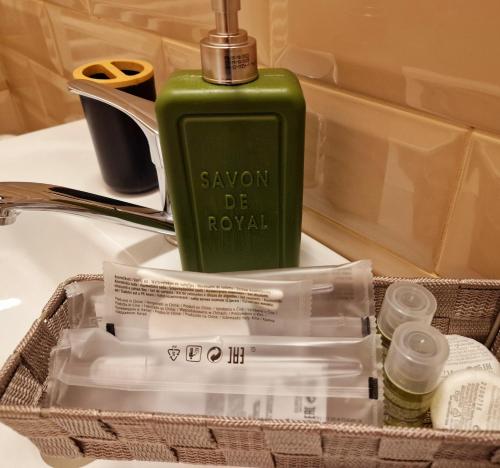 a green bottle of soap sitting on top of a sink at MBI Smart Central in Craiova