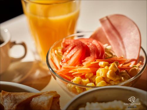 a bowl of food with corn and vegetables next to a drink at Daiwa Roynet Hotel Kawasaki in Kawasaki