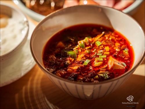 a bowl of soup sitting on a table at Daiwa Roynet Hotel Kawasaki in Kawasaki