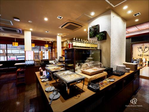 a restaurant with a counter with food on it at Daiwa Roynet Hotel Kawasaki in Kawasaki