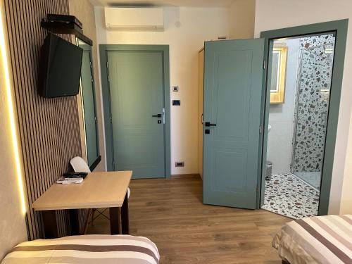 a room with two doors and a table and a bed at Villa Mukinja - Wellness & Spa in Plitvička Jezera