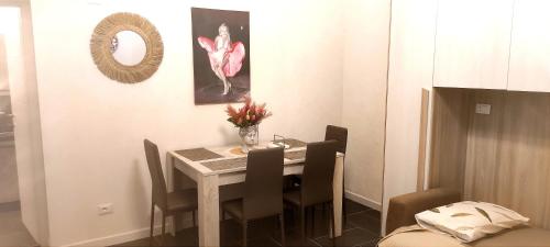 a dining room table with chairs and a vase of flowers at Dimora Falcone in Bari