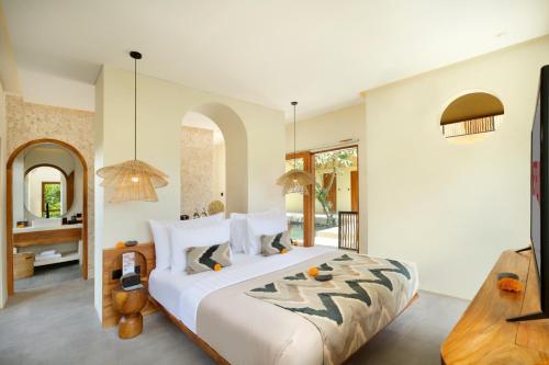 a bedroom with a large bed and a bathroom at Suara Alam Hotel Ubud by Ini Vie Hospitality in Ubud