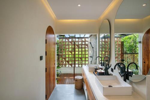 a bathroom with a sink and a mirror at Suara Alam Hotel Ubud by Ini Vie Hospitality in Ubud