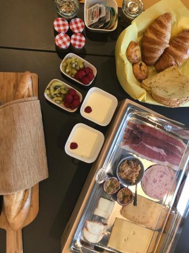 una mesa cubierta con muchos tipos diferentes de comida en B&B Presende, en Veurne