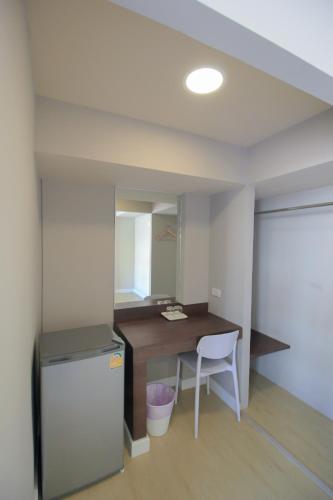 an empty room with a desk and a refrigerator at The Sea Bangsaen Hotel in Ban Bang Saen (1)