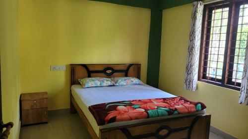 a bedroom with a bed in a room with green walls at Allora homestay in Vagamon