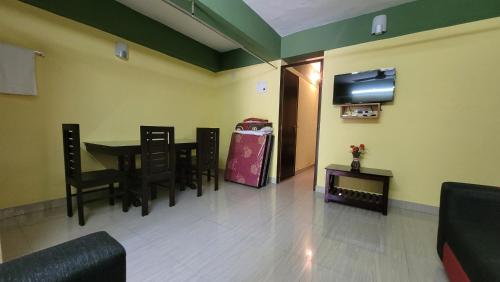 a waiting room with a table and chairs and a television at Allora homestay in Vagamon