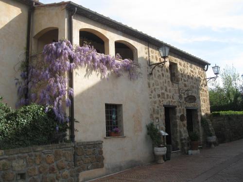 a building with purple flowers on the side of it at Sovana Hotel & Resort in Sovana