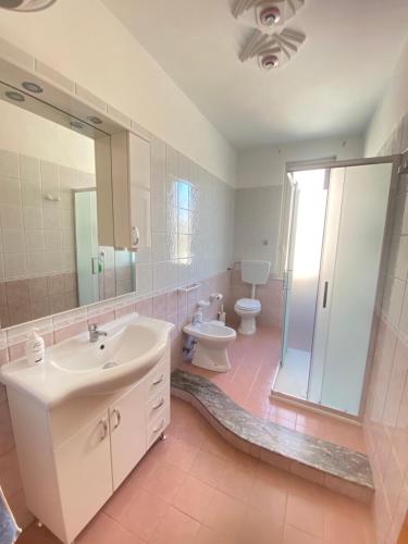 a bathroom with a sink and a toilet and a mirror at Twinsuite in Licata