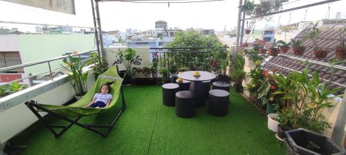 a child sitting in a hammock on a balcony at Homestay Halley in Da Nang